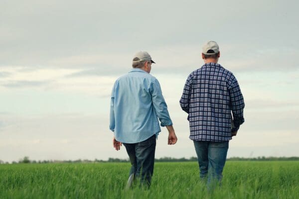 Two farmers discussing the potential benefits of wind farm developments across Queensland